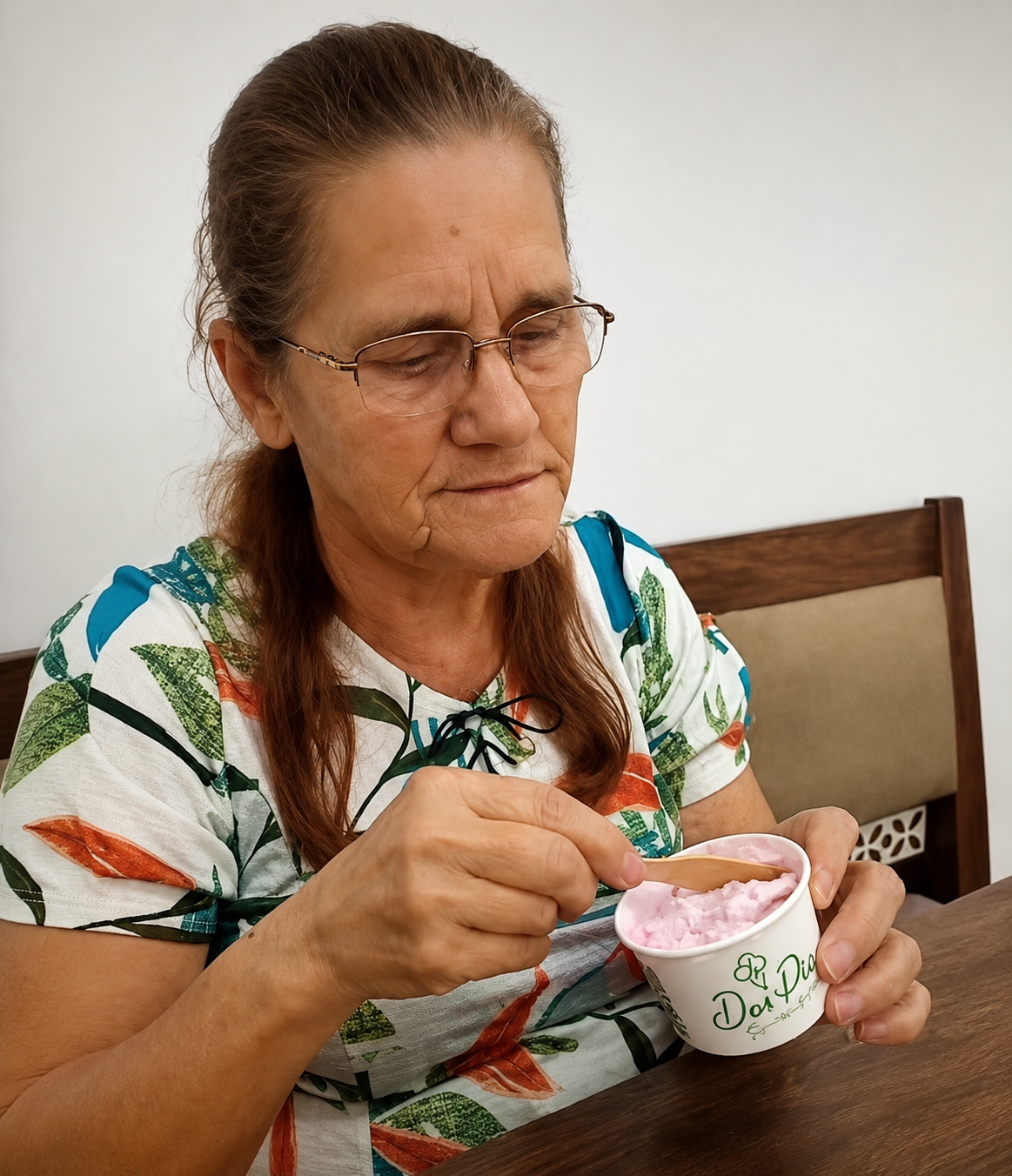 Dona Marga segurando copinho com colher e saboreando sobremesa com carinho