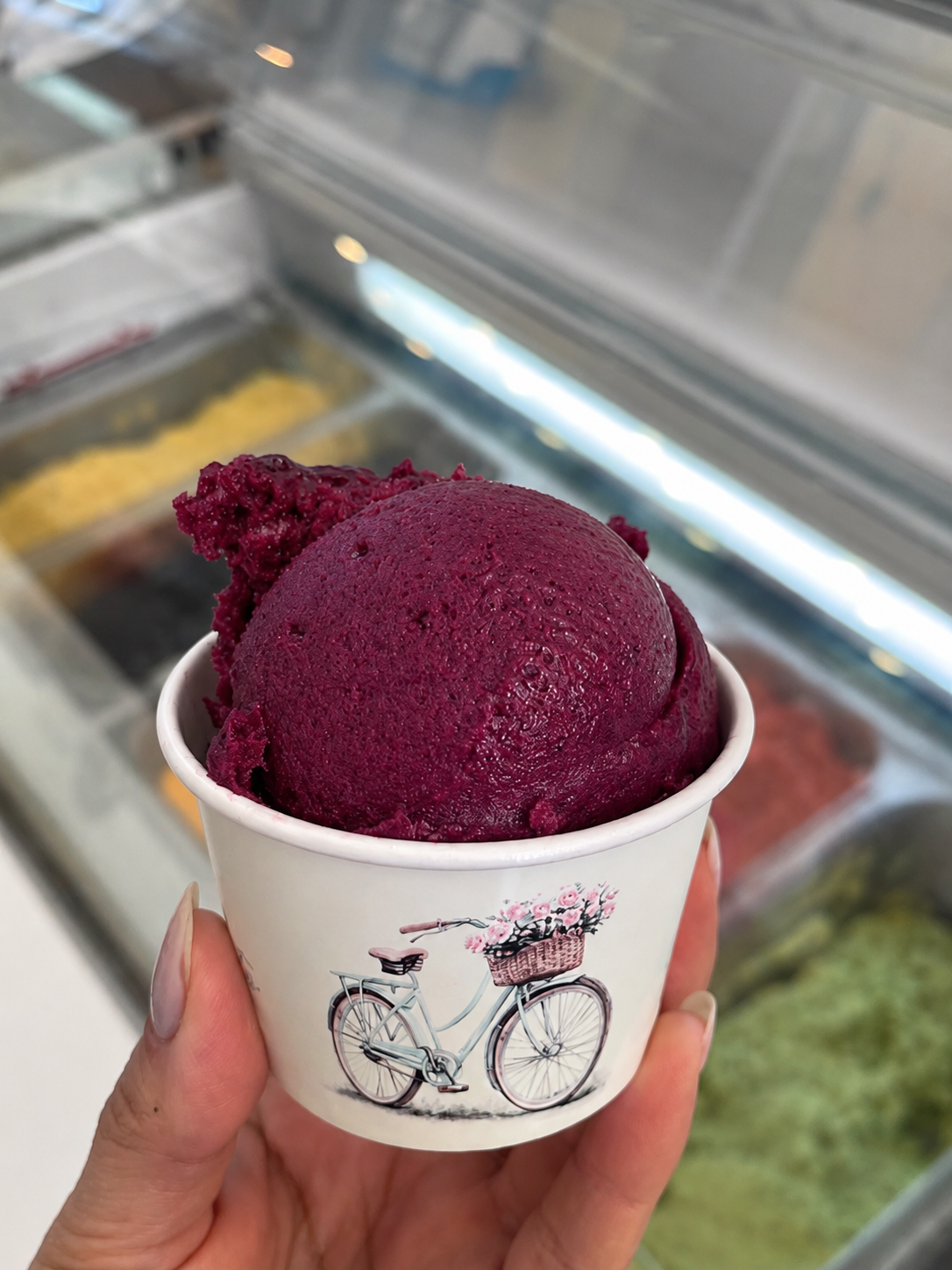 Copinhos de gelato com sabores pistache, morango e amarena