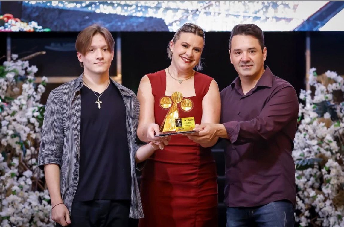 Família fundadora da Di Piallato reunida segurando o troféu dourado de premiação