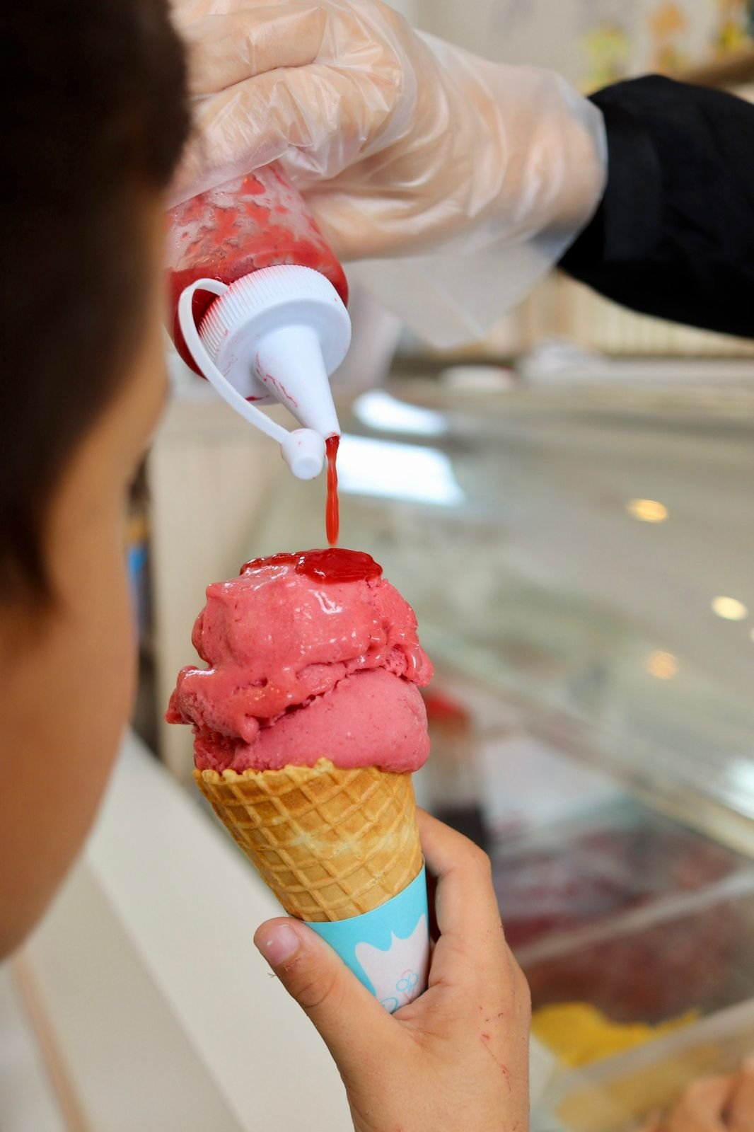 Gelato artesanal Di Piallato com calda de chocolate escorrendo, evidenciando textura e técnica artesanal